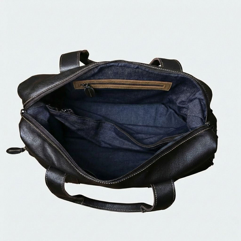 Intérieur ouvert du sac de voyage : doublure en tissu bleu denim avec poche zippée intérieure et parois structurées