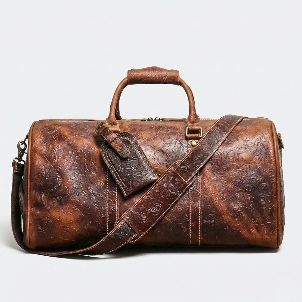 Vue de face avec bandoulière et étiquette : sac de voyage cuir brun embossé motifs floraux cabine