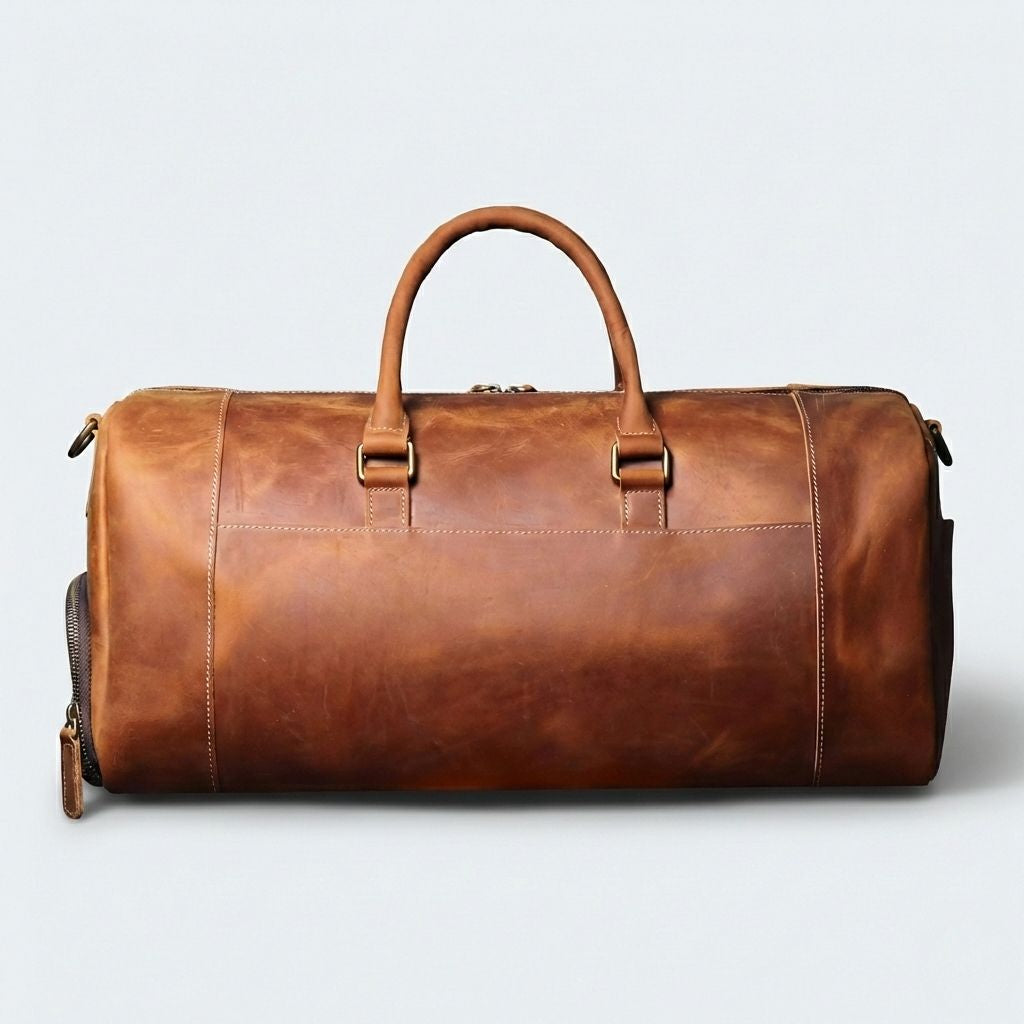 Dos du sac de voyage cuir cognac caramel, anneaux D dorés et dos lisse avec surpiqûres blanches
