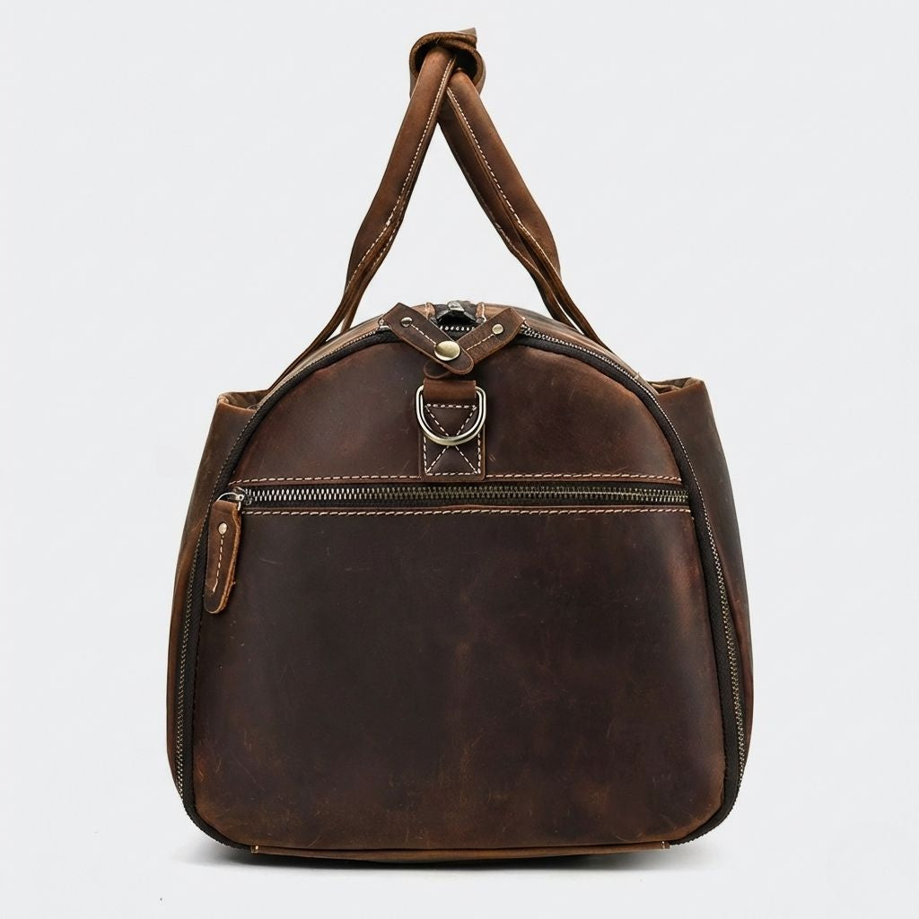 Côté du sac de voyage en cuir brun, poche zippée demi-lune et anneau D en laiton pour bandoulière