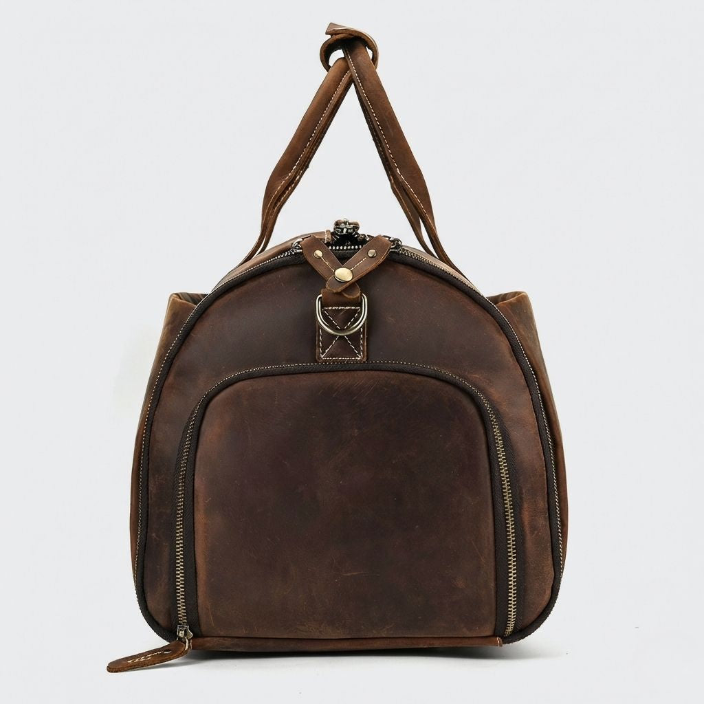 Face circulaire du sac de voyage cuir brun foncé, grande poche demi-lune et languette de zip cuir