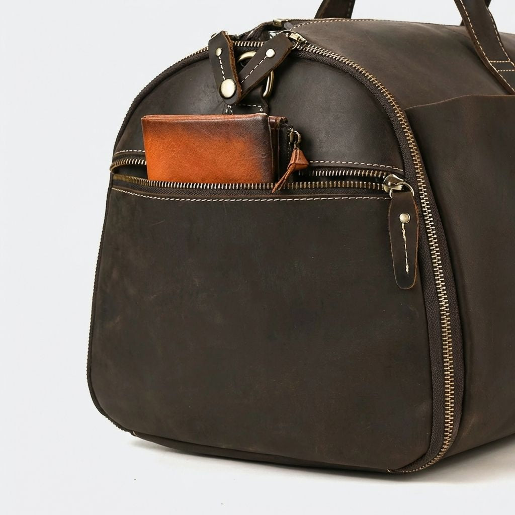 Poche avant du sac de voyage cuir ouverte avec un portefeuille et un porte-monnaie en cuir cognac