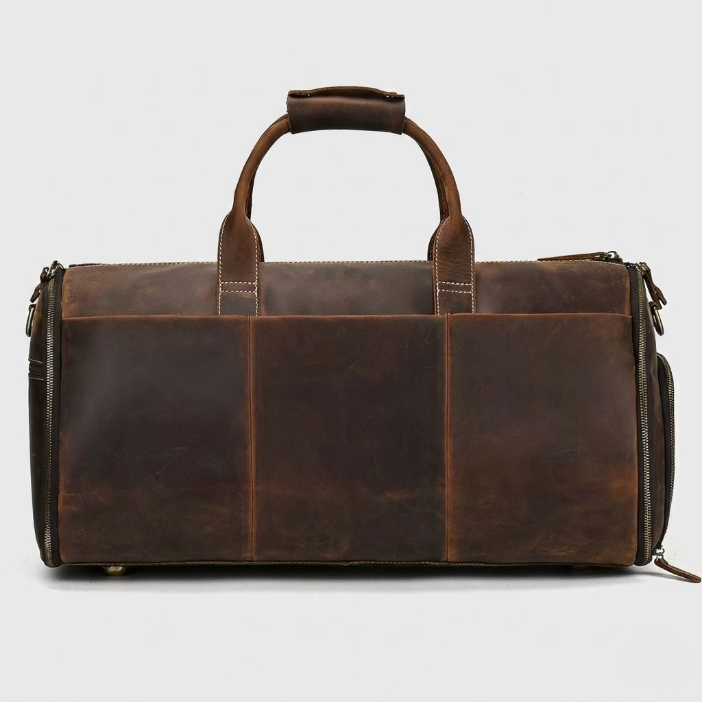 Dos du sac de voyage en cuir brun chocolat, assemblage de panneaux et pieds protecteurs en laiton