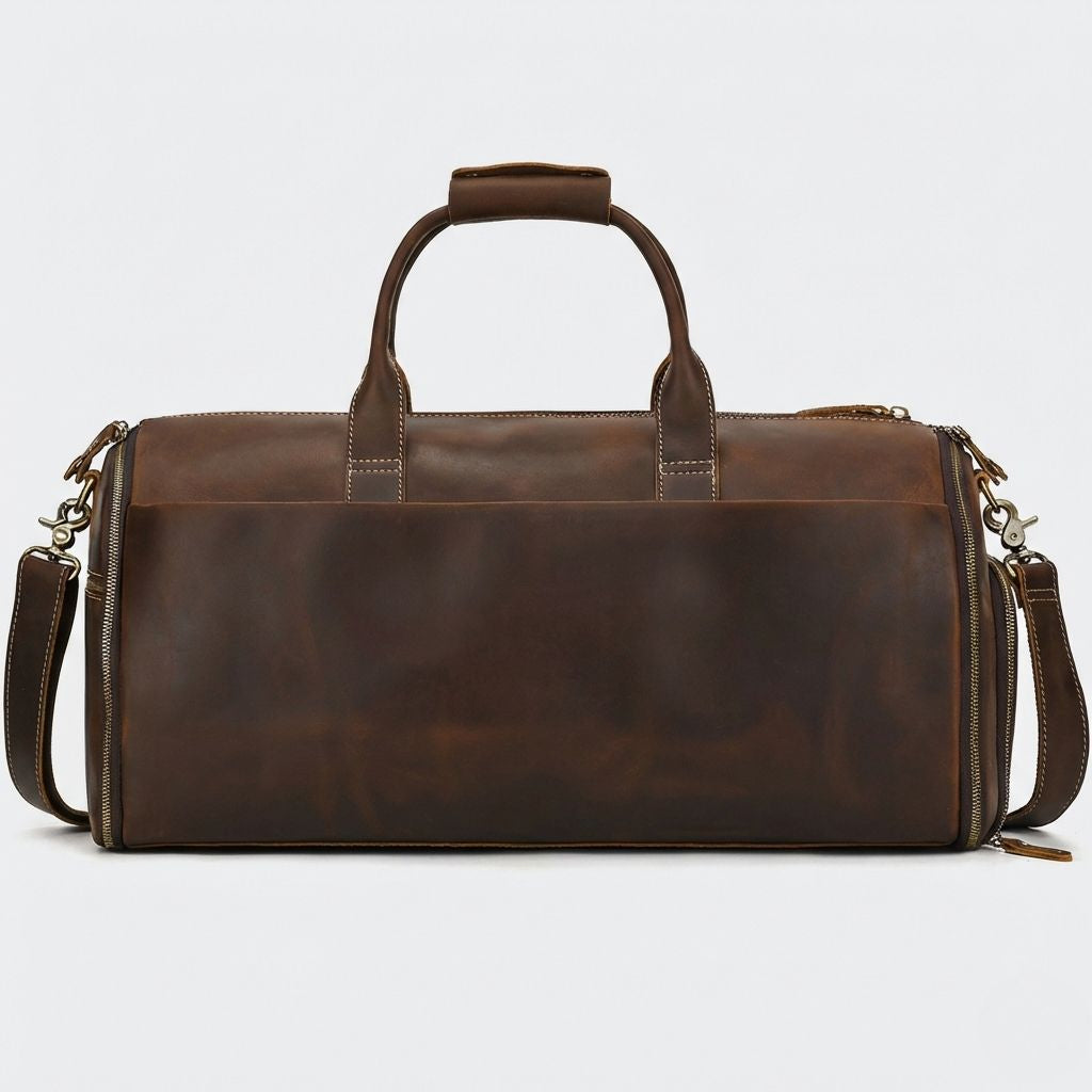 Sac de voyage cuir brun profond vu de dos, bandoulière réglable fixée aux deux mousquetons latéraux