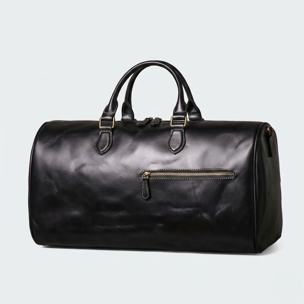 Sac de voyage cabine en cuir pleine fleur noir, vue 3/4 avec poche frontale zippée et hardware doré