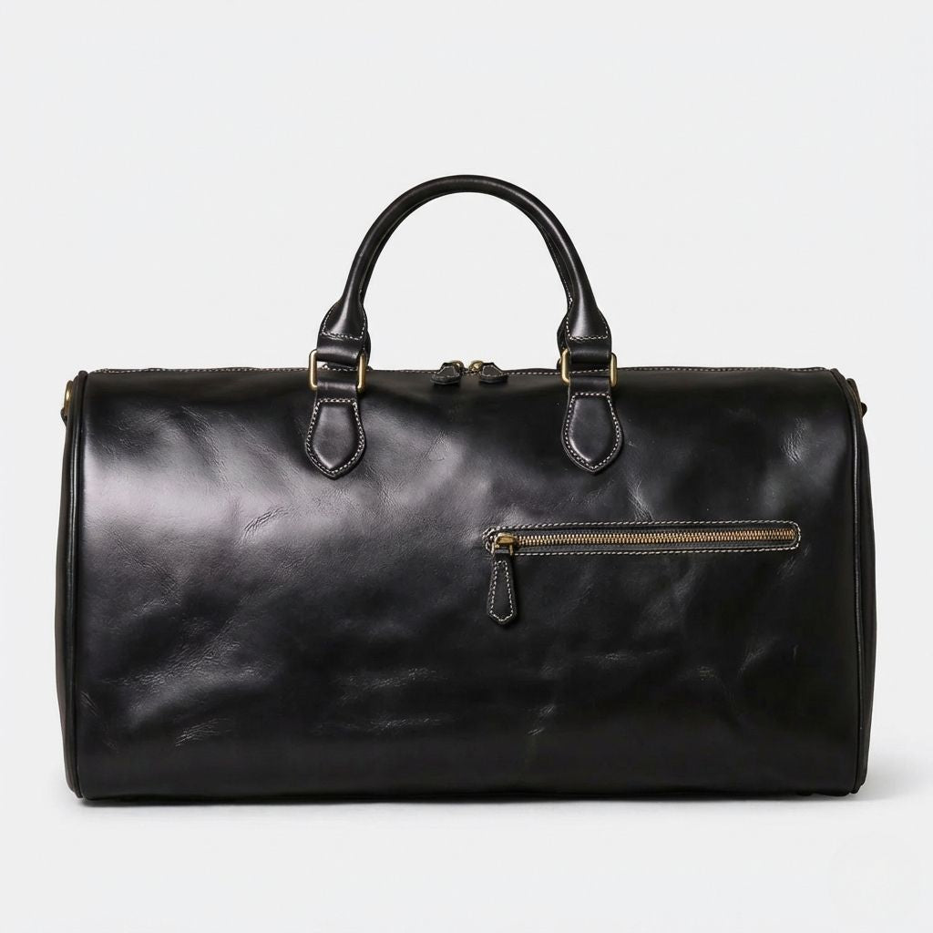 Face avant du sac de voyage cabine cuir lisse noir, poche frontale et double tirette en laiton doré