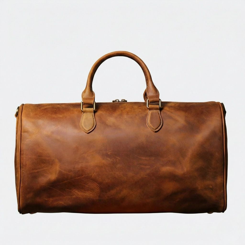 Dos du sac de voyage cabine en cuir cognac, profil lisse avec surpiqûres blanches et anneau D latéral