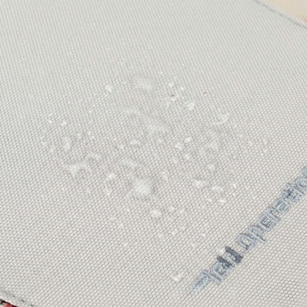 Gros plan sur le tissu déperlant gris du sac à dos de randonnée avec des gouttes d'eau perlant à la surface Image