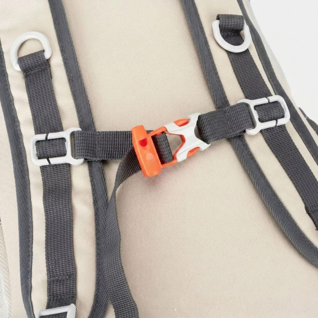 Gros plan sur la sangle poitrine à clip orange d'un sac à dos randonnée léger en tissu gris clair déperlant.