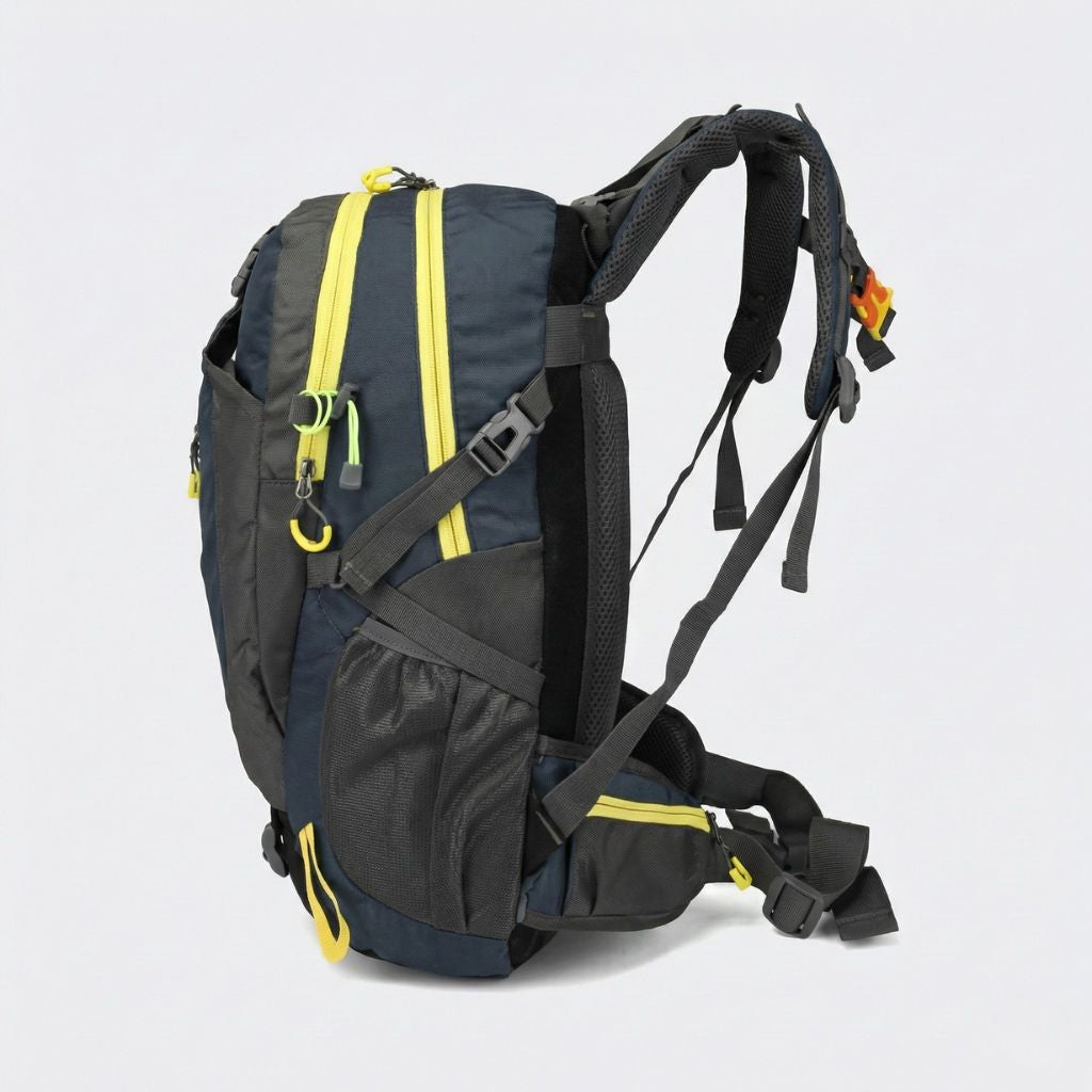 Vue de côté d'un sac à dos randonnée 40L bleu marine et gris, liserés jaune, bretelles et sangles latérales.