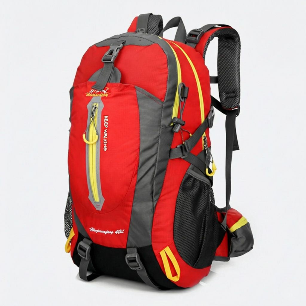 Sac à dos randonnée 40L rouge vif et gris, liserés jaune fluo, bretelles rembourrées et poches frontales zippées.