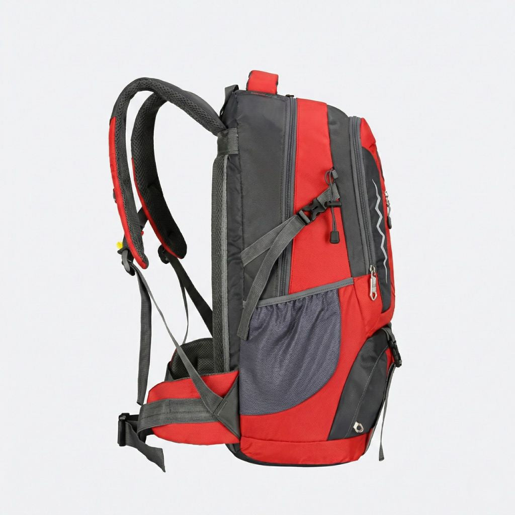 Vue de côté d'un sac à dos randonnée 60L rouge et gris, poche filet latérale et sangle de compression réglable.