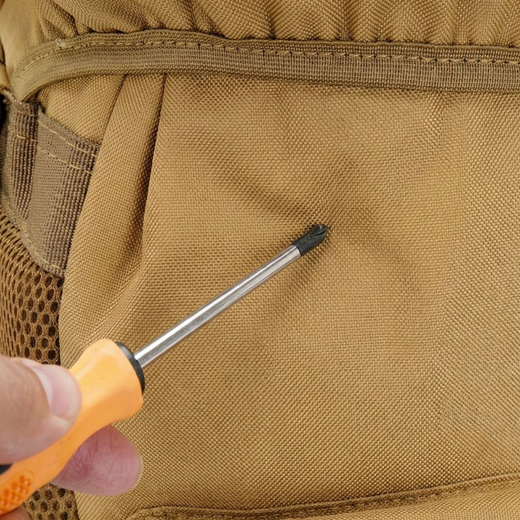 Gros plan sur le système MOLLE d'un sac à dos tactique beige kaki, avec un tournevis glissé dans les sangles Image