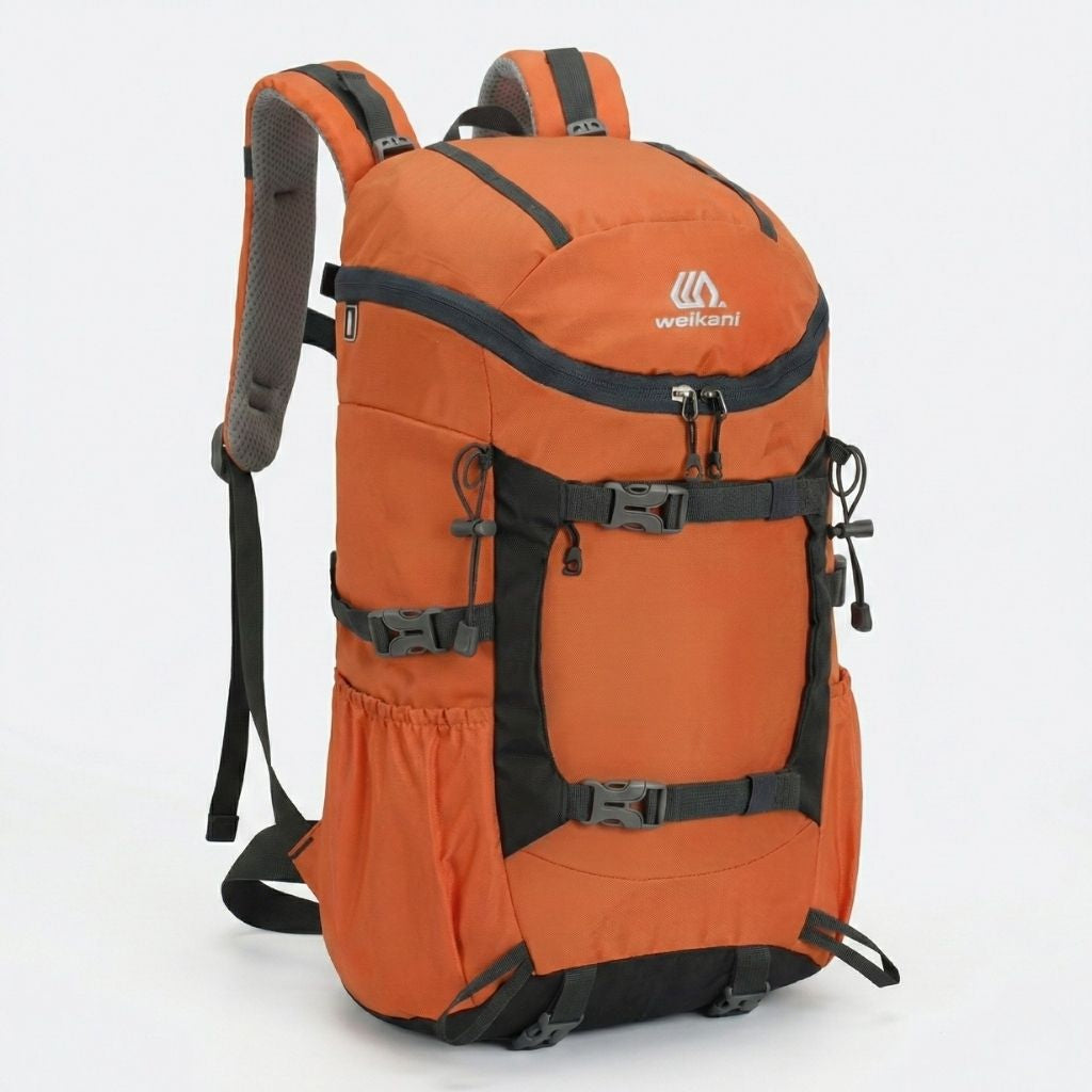 Sac à dos randonnée orange et noir compatible hydratation, vue 3/4, sangles réglables et bretelles larges.