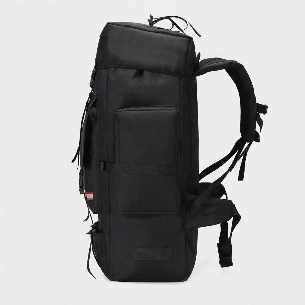 Sac à dos tactique noir 130L vu de profil, poche latérale plate, bretelles ergonomiques et sangles de compression