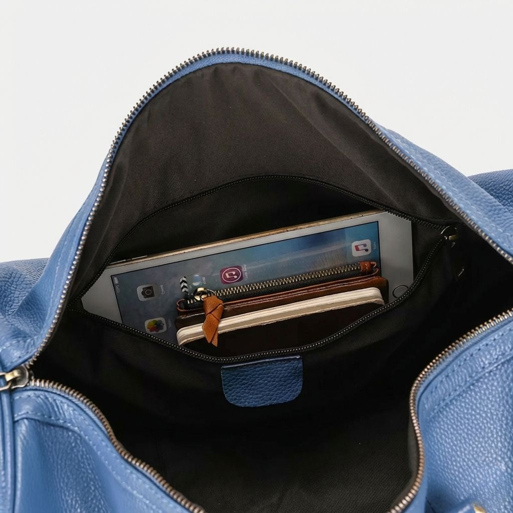 Poche frontale zippée ouverte du sac cabine bleu avec tablette et portefeuille, doublure noire