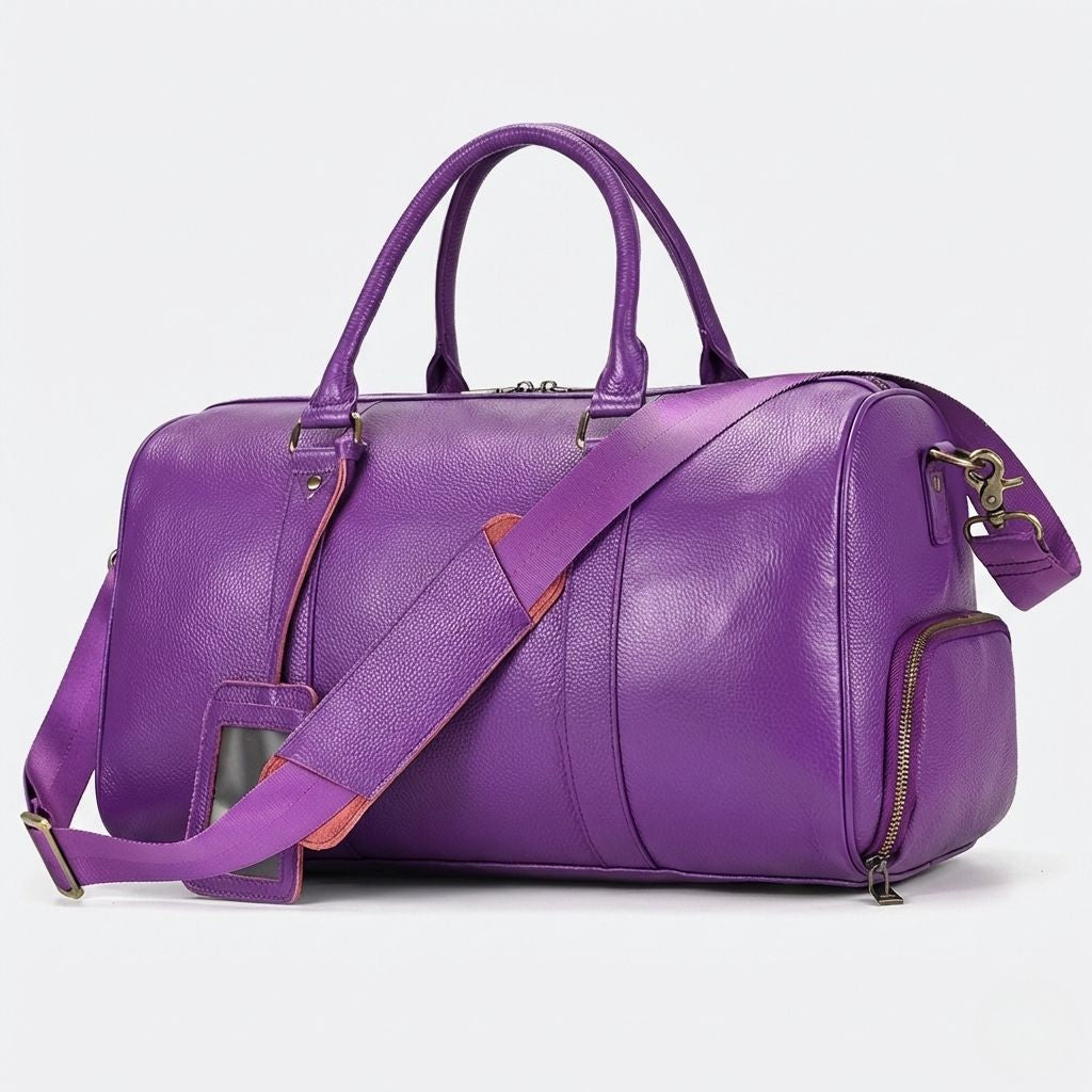 Sac de voyage cabine cuir grainé violet avec bandoulière, vue trois quarts avant sur fond blanc
