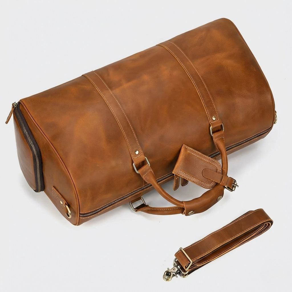 Sac de voyage cuir crazy horse cognac vu de côté couché, bandoulière cuir détachée avec crochets