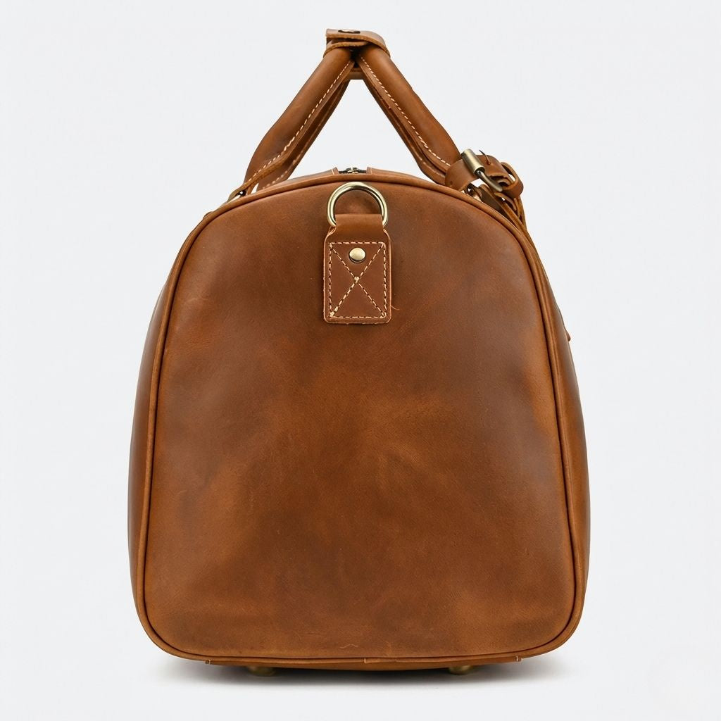 Profil latéral gauche du sac de voyage cuir crazy horse cognac, anneau D et poignées courtes en cuir