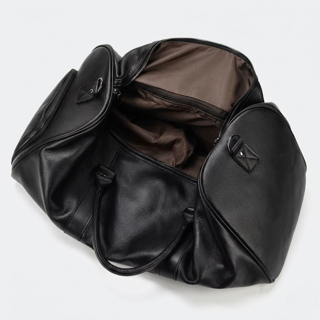 Intérieur du sac de voyage cuir grainé noir ouvert, doublure marron et compartiments secondaires visibles