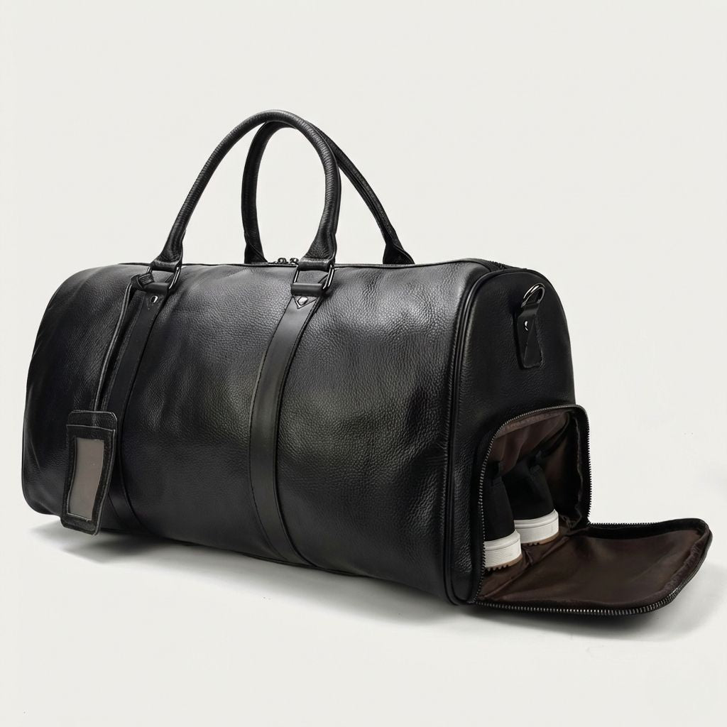 Sac de voyage cuir grainé noir avec poche à chaussures ouverte, chaussures blanches et étiquette cuir
