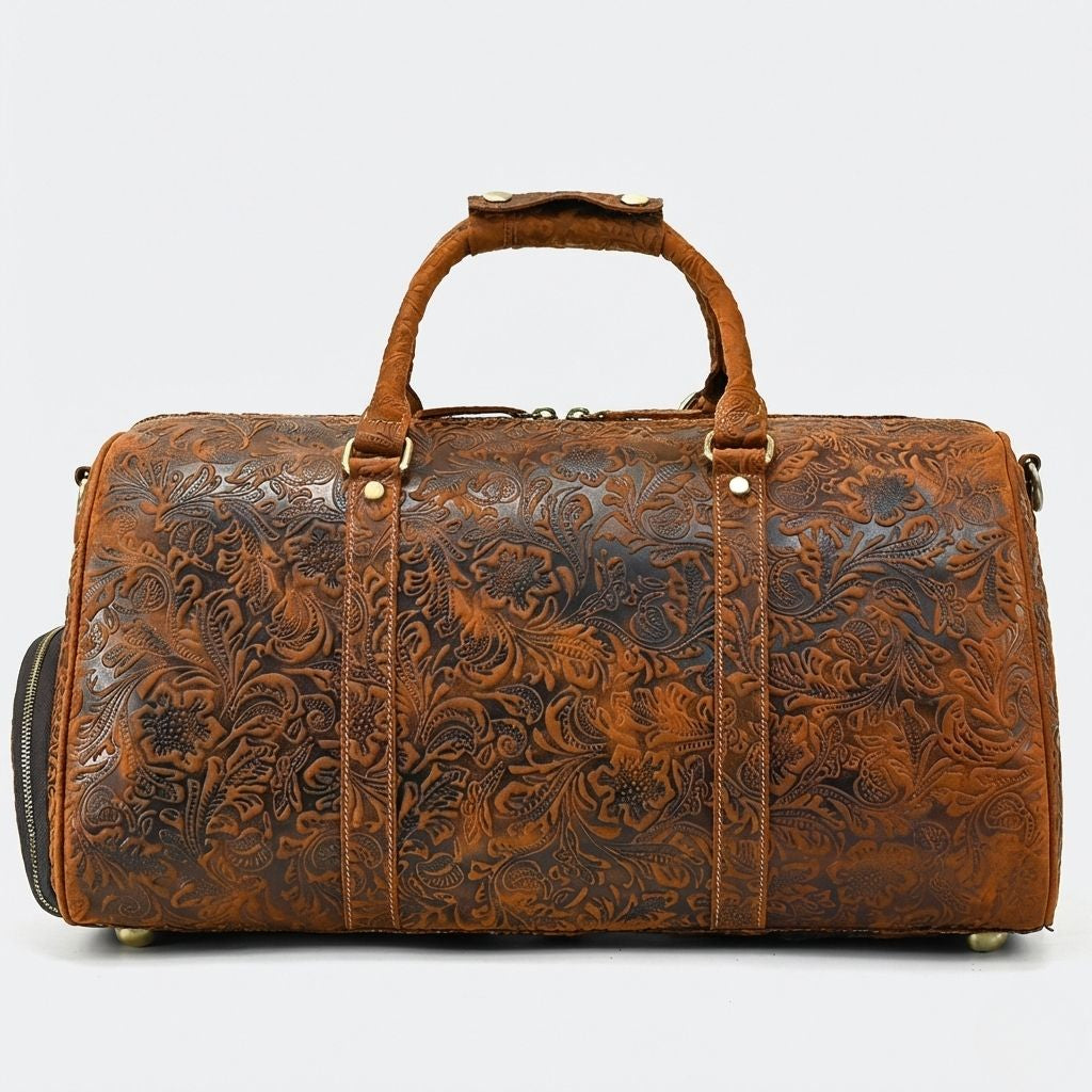 Vue de face du sac de voyage cuir brun tabac embossé floral, pieds laiton et double poignée en cuir