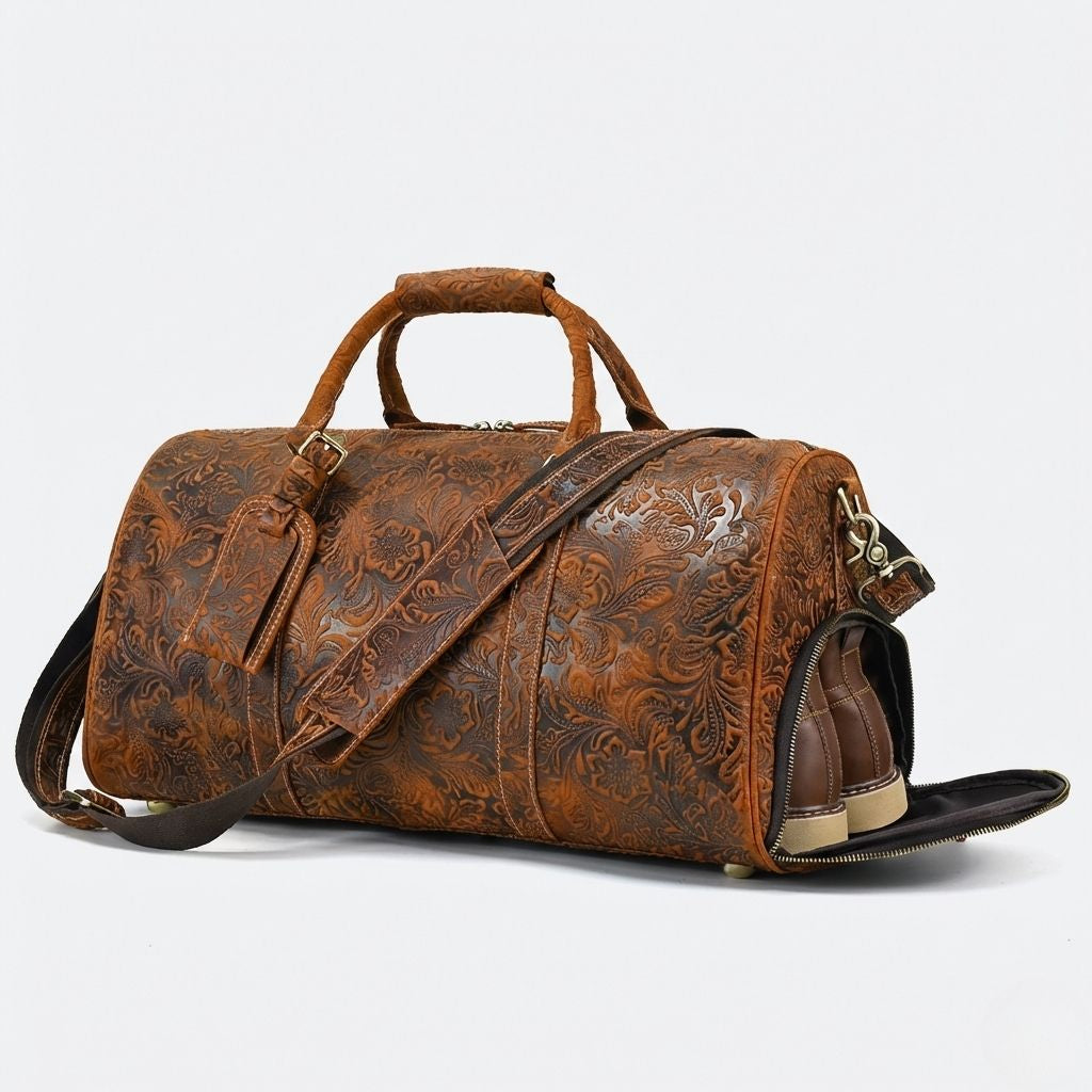 Vue 3/4 face, sac de voyage cuir cognac embossé floral avec chaussures en cuir visibles dans le compartiment