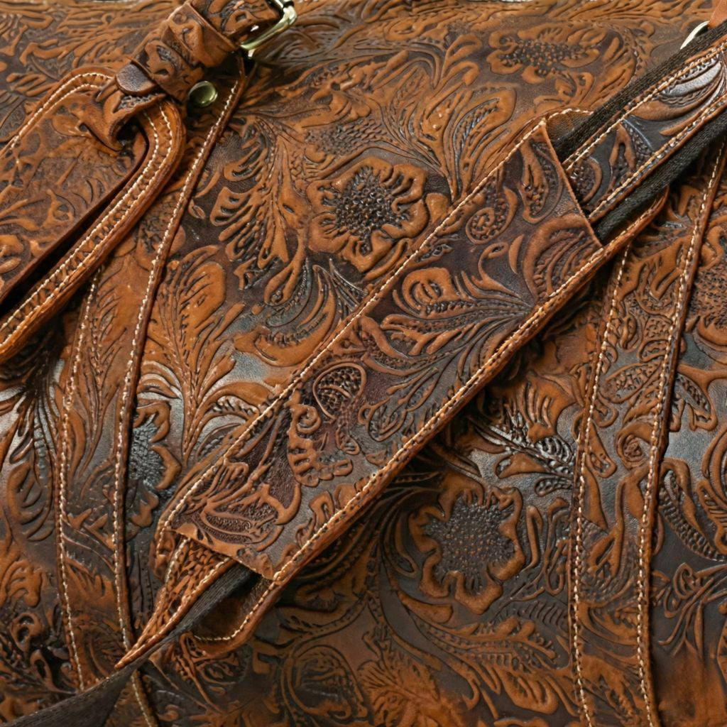Gros plan de la bandoulière et du cuir embossé motif floral bicolore miel et brun d'un sac de voyage cabine Image