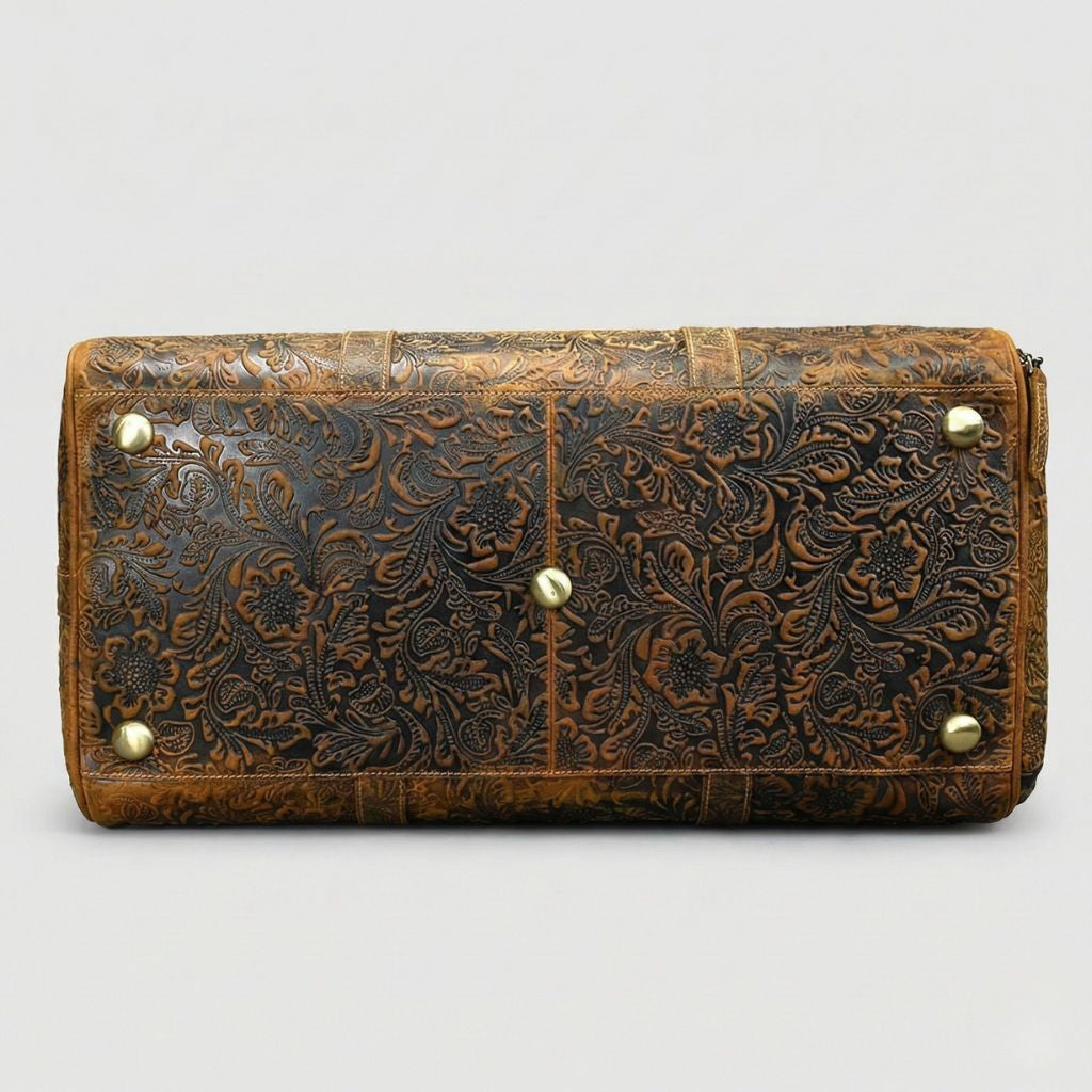 Vue de dessous du sac de voyage en cuir bicolore miel et brun embossé motif floral, pieds de protection en laiton Image
