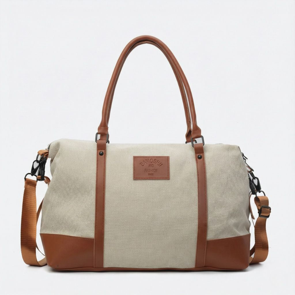 Sac de voyage en toile beige avec poignées et renforts en cuir marron, bandoulière réglable amovible