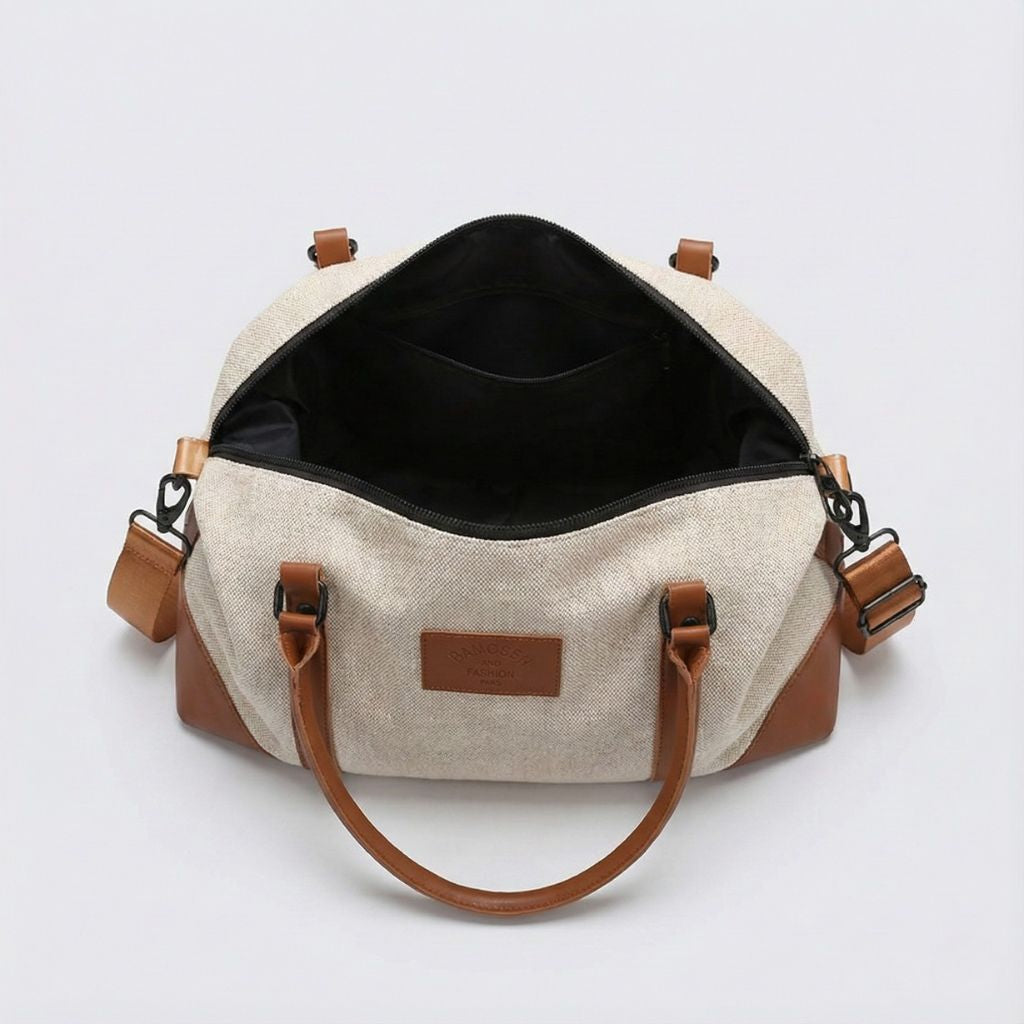 Sac de voyage en toile beige avec grand compartiment principal zippé et poignées en cuir marron