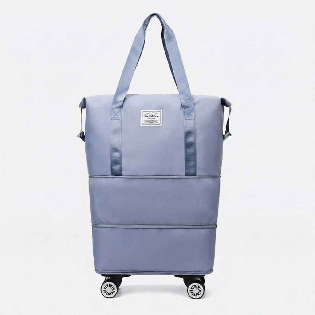 Sac de voyage femme extensible gris bleu sur quatre roulettes amovibles, vue de face, deux anses et étiquette tissu