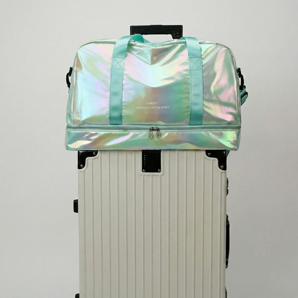 Sac de voyage holographique vert menthe irisé posé sur une valise blanche, poignées vertes et poche chaussures