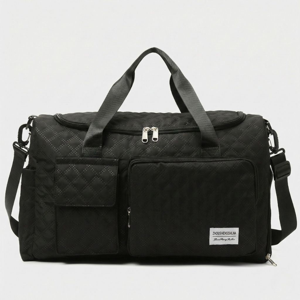 Sac de voyage femme cabine matelassé noir, vue de face, deux poignées, poche carrée à rabat et grande poche zippée
