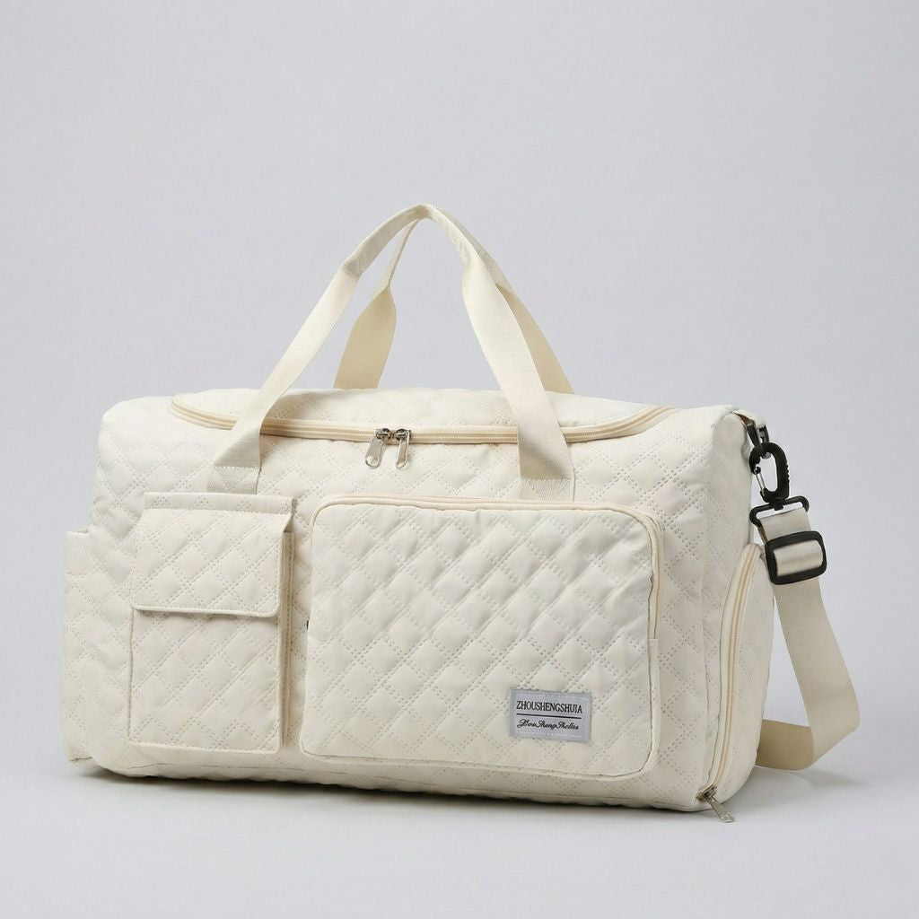 Sac de voyage femme matelassé blanc cassé, vue trois-quarts, poches frontales et bandoulière réglable visible