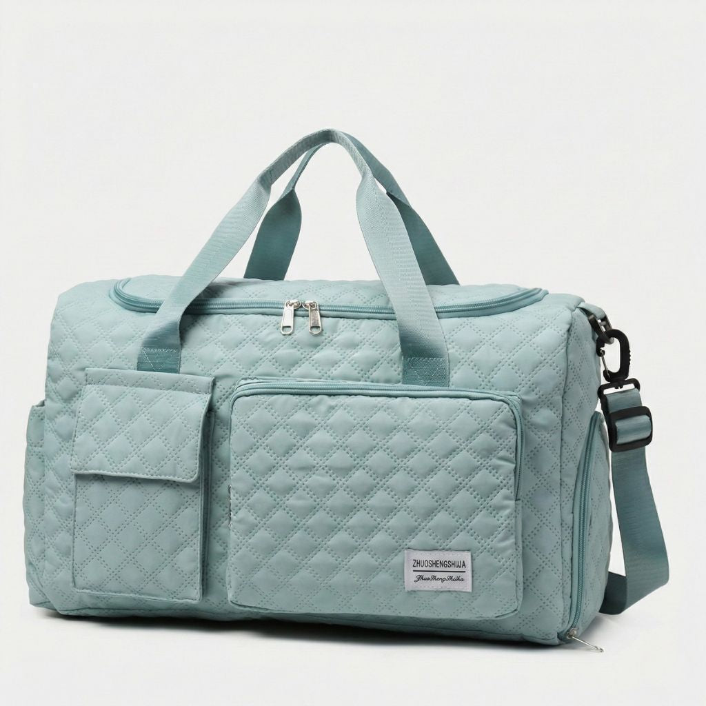 Sac de voyage femme matelassé vert d'eau, vue trois-quarts avant, poignées textiles et bandoulière noire réglable