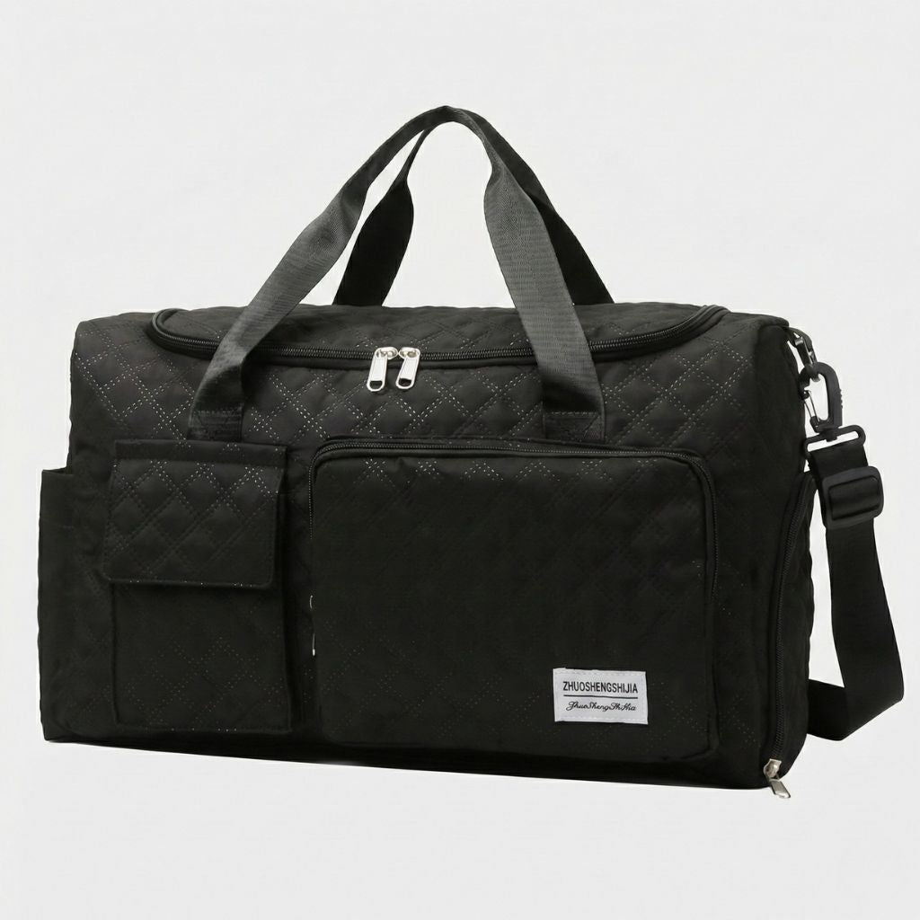 Sac de voyage femme cabine matelassé noir, vue trois-quarts avant, bandoulière réglable et poches frontales zippées