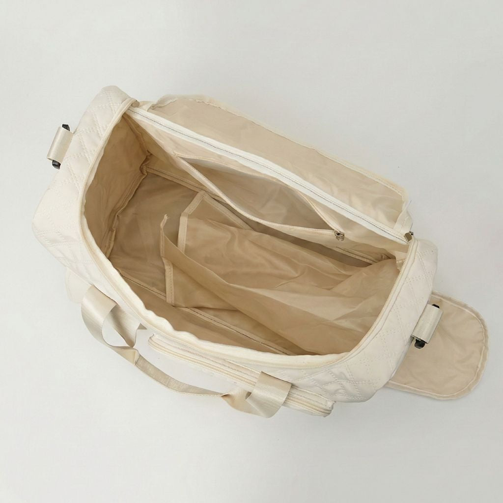 Compartiment principal vide du sac de voyage femme matelassé blanc cassé, doublure beige et poche interne zippée