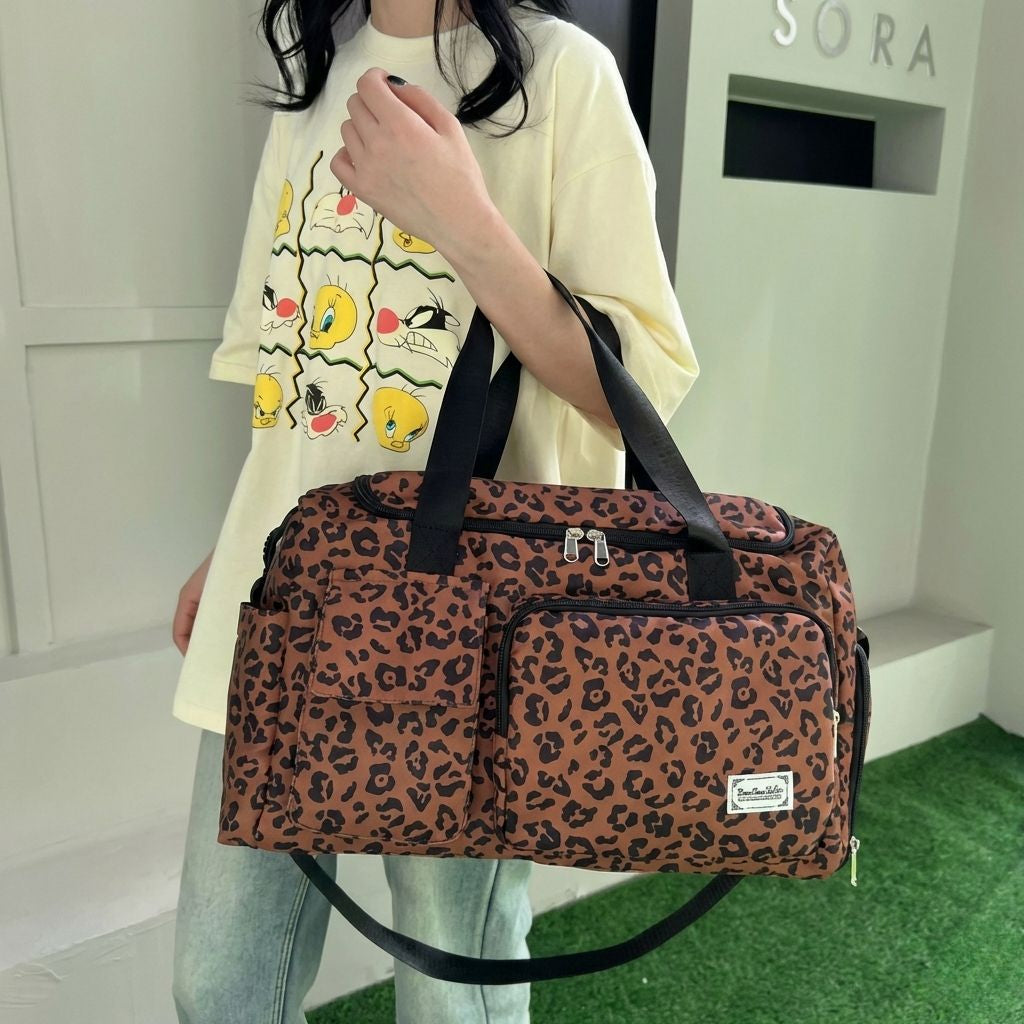 Femme tenant un sac de voyage cabine imprimé léopard marron caramel par les poignées dans une boutique élégante