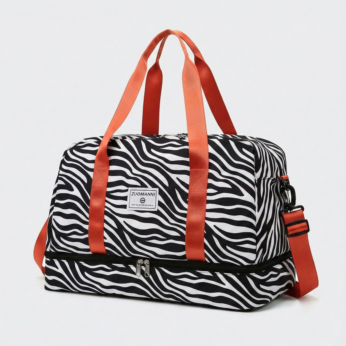 Sac de voyage femme à motifs zèbre noir et blanc grande capacité avec anses orange, bandoulière et compartiment inférieur zippé, sur fond uni blanc gris