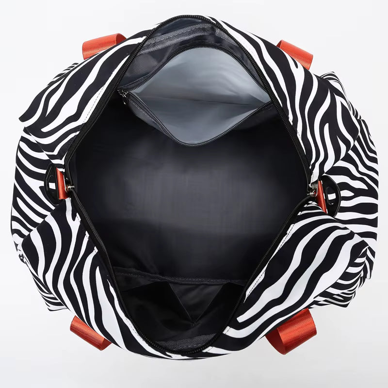 Sac de voyage femme à motifs zèbre grande capacité ouvert vu de dessus avec grand compartiment et poche intérieure zippée