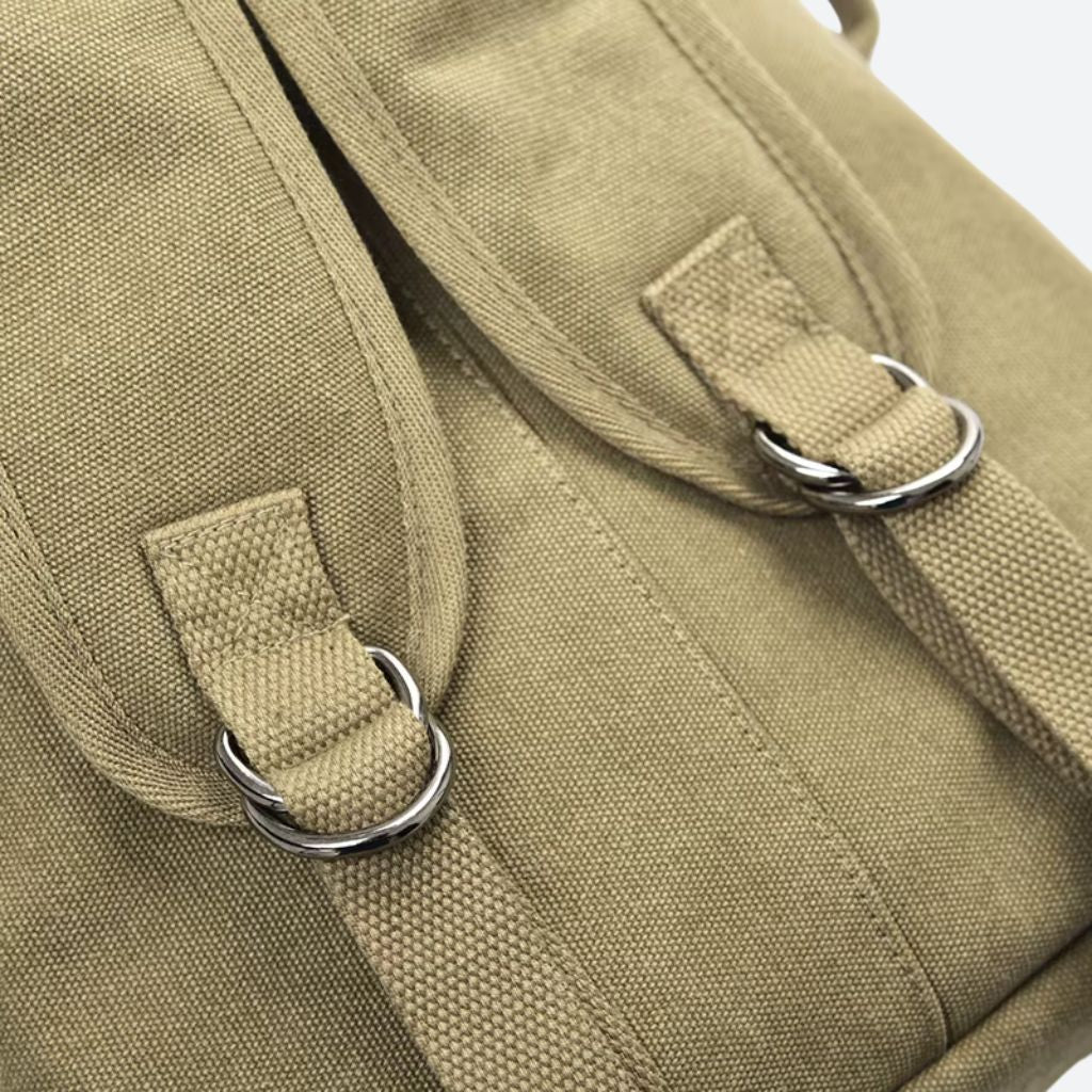 Gros plan sur les anneaux ronds en métal argenté servant de fixation pour la bandoulière du sac canvas kaki