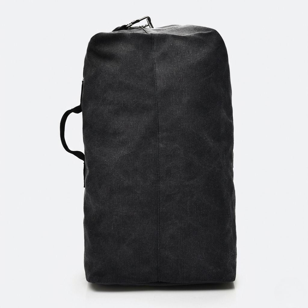 Vue latérale du sac de voyage en toile canvas noir, couture centrale visible et poignée latérale textile renforcée