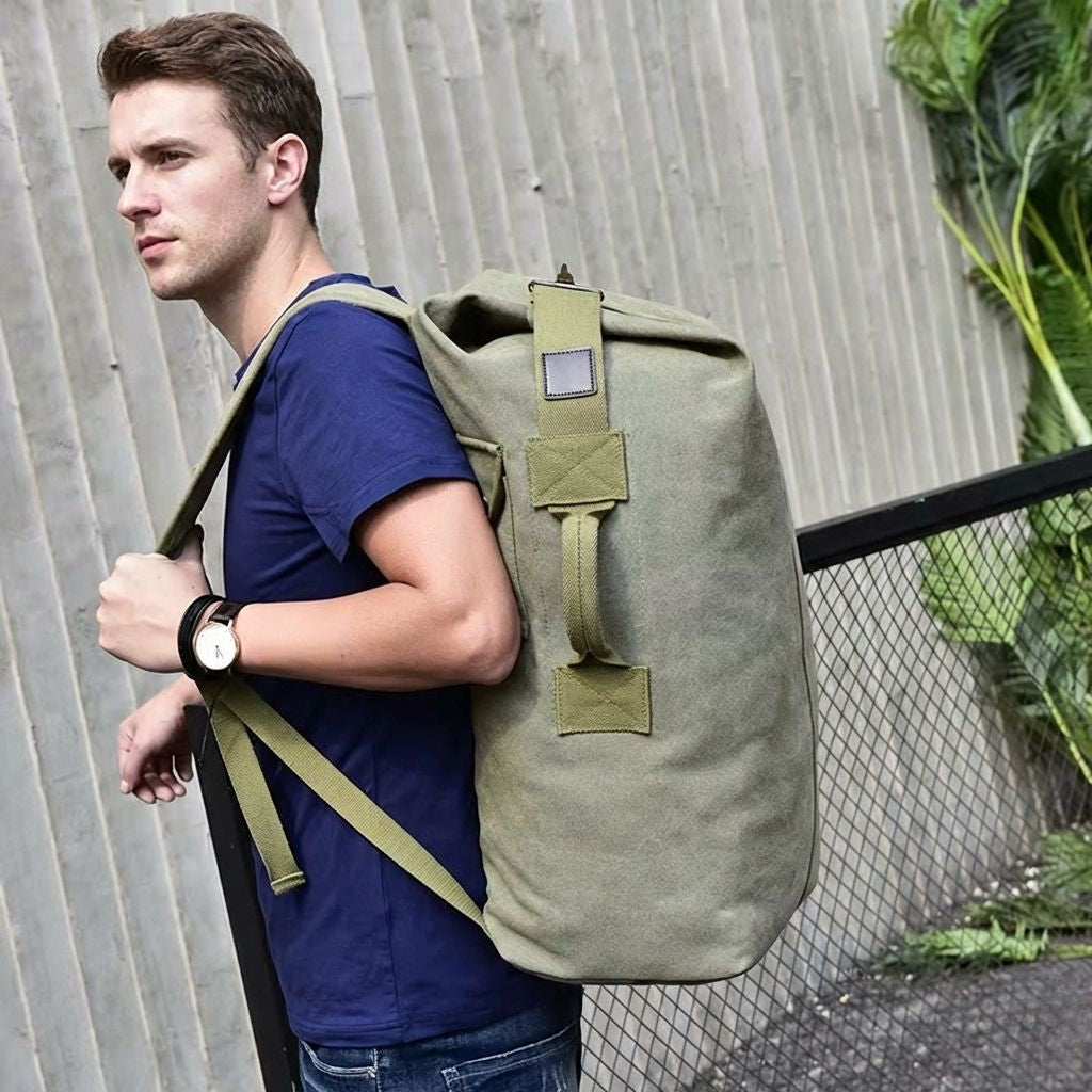Homme portant sur le dos un grand sac de voyage en toile canvas kaki, style militaire décontracté Image