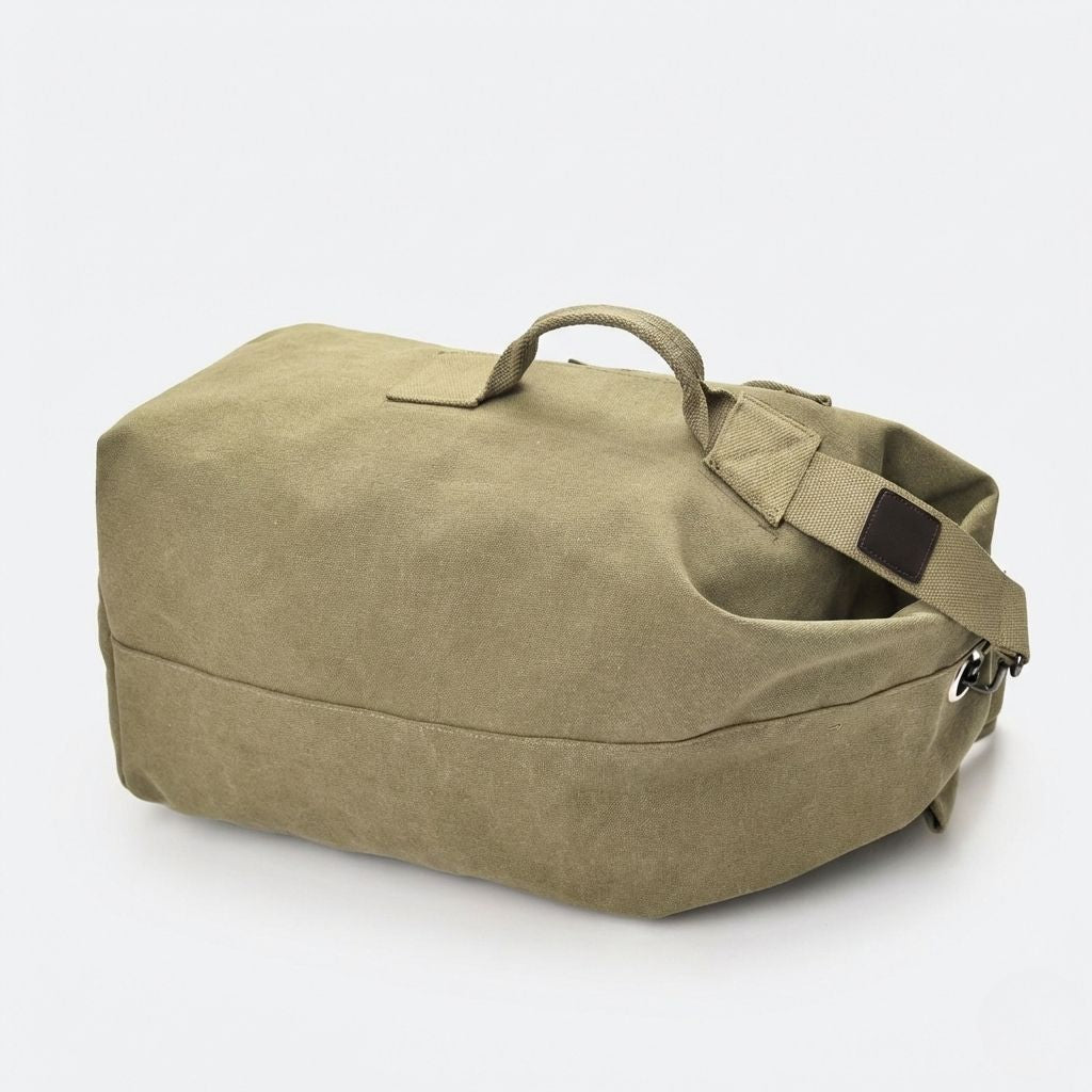 Sac de voyage canvas kaki vu légèrement du dessus, avec poignée et bandoulière réglable sur fond blanc