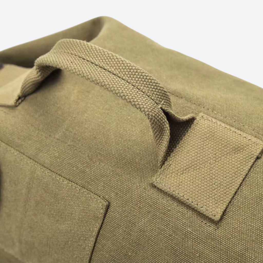 Gros plan de la poignée tressée en toile kaki d'un sac de voyage canvas et de sa poche latérale bouton Image