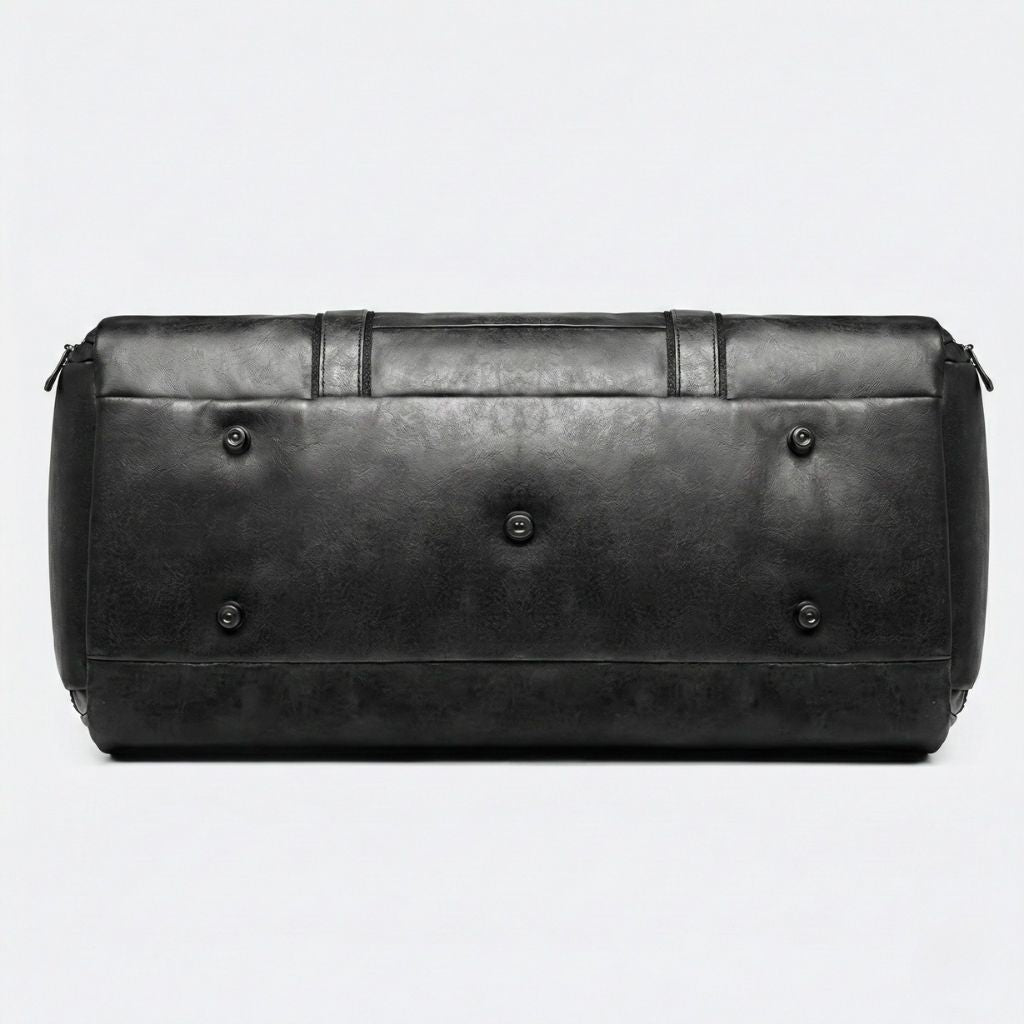 Fond du sac de voyage homme noir avec cinq rivets métal protecteurs disposés pour surélever le sac posé au sol