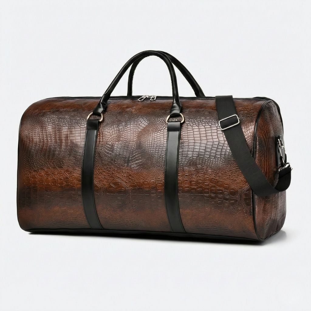 Sac de voyage en simili cuir marron effet crocodile, vue trois quarts avec poignées noires et bandoulière noire