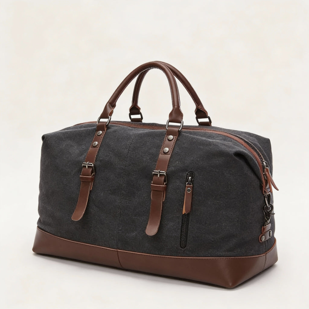 Sac de voyage en toile gris anthracite avec garnitures cuir brun, deux lanières à boucles et fermeture zippée