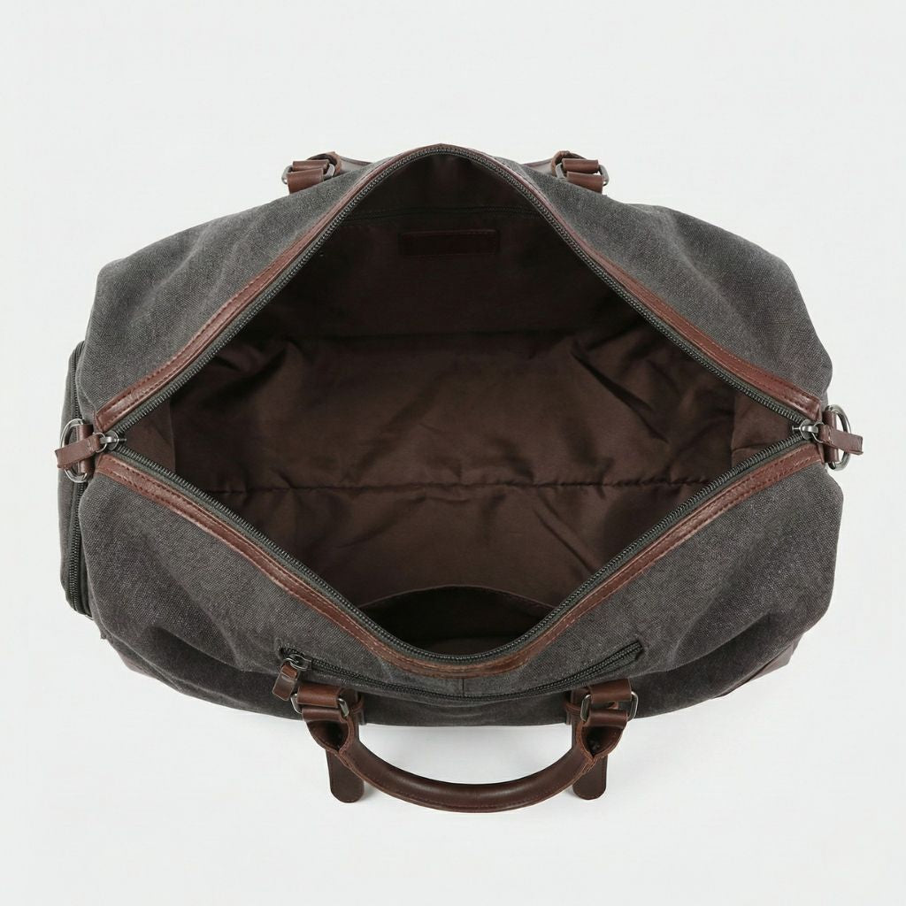 Vue du dessus de l'intérieur du sac de voyage en toile gris ouvert, large compartiment et doublure brun foncé